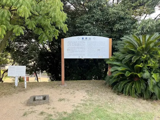 The image depicts a park or natural setting with informational signs. One sign appears larger and contains text, likely providing details about the location, which is labeled as "黒東山" (Kurohigashiyama). There's also another smaller sign nearby. The area is surrounded by greenery, including trees and plants, suggesting a peaceful outdoor environment.

Image Credits: Wikimedia / ほっきー / CC0