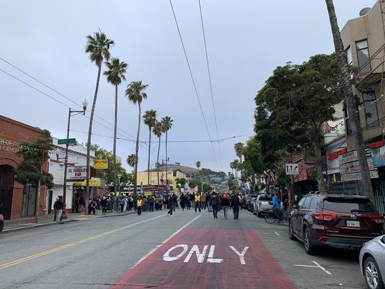 Crowd of people at end of Mission Street filling the intersection