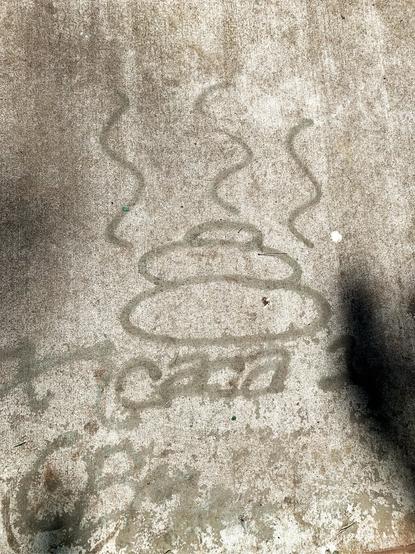 Image of a cartoon drawing on gray concrete of a pile of turd with vertical squiggly lines like steam emanating from it with the word “caca” written under it in lowercase