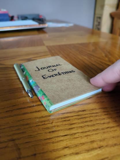 Cardboard covered small booklet with about 80 pages, shown closed.