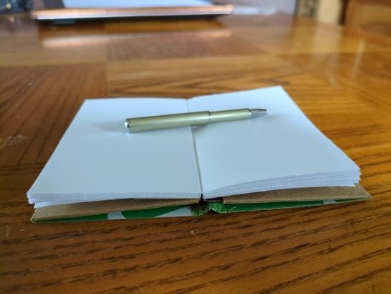 Booklet shown open and lying flat, due to sewn sections and careful cover construction.
