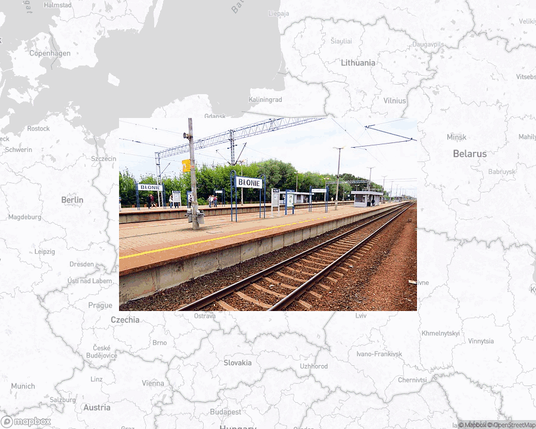 A photo of or from a train station from the linked website, overlaid on a cropped world map where it's located.