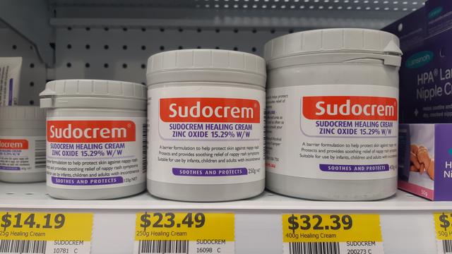Three containers of Sudocrem healing cream on a shelf
