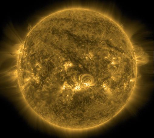 Die ganze erdzugewandte Seite der Sonne in gelber Farbe. In der Mitte knapp unterhalb des Äquators einige helle Bereiche, von denen sogenannte koronale Loops wie dünne Lichtbögen ausgehen und zur Oberfläche zurückführen. Ansonsten ein vergleichsweise ruhiger Anblick. Links und weniger stark auch rechts an den Rändern eine diffuse Strahlung, die weit ins All reicht.