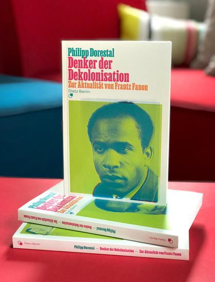 Mehrere Exemplare unserer Neuerscheinung »Denker der Dekolonisation. Zur Aktualität von Frantz Fanon« von Philipp Dorestal aufeinander gestapelt fotografiert