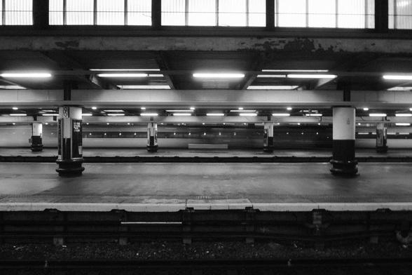 Photo of the train station with a train passing.