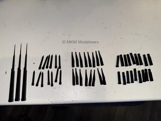 Multiple copies of 4 different tower shapes on a white table.