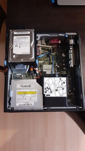 Der geöffnete DELL OptiPlex 755 Desktop PC von oben fotografiert liegend auf einem dunkelbraunen Esstisch an dessen Kannte. Man kann noch den Hellen Boden sehen.