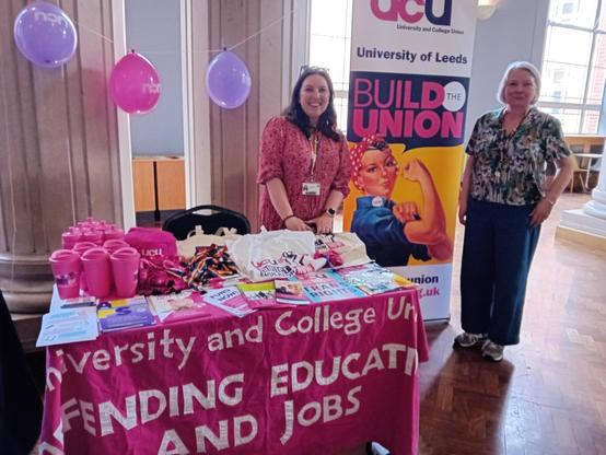 UCU recruitment stall with two smiling reps and lots of pink and purple