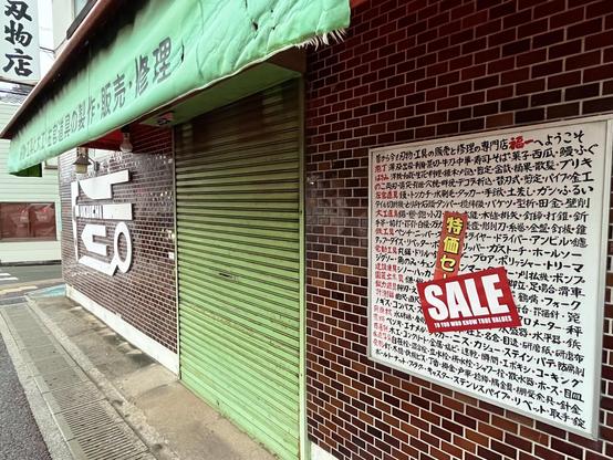 Another view of the shop, showing its green shutter and awning.
