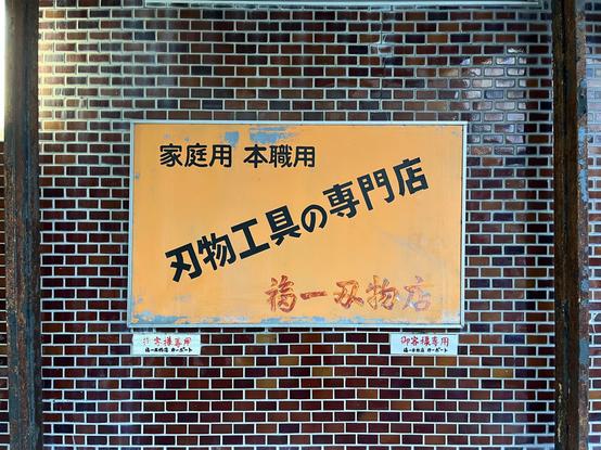Another sign of the shop, this time an orange rectangle with a typography that looks cut by hand.