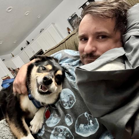 Selfie of Reka and me on the couch with her laying on me and looking all happy and me just looking tired.