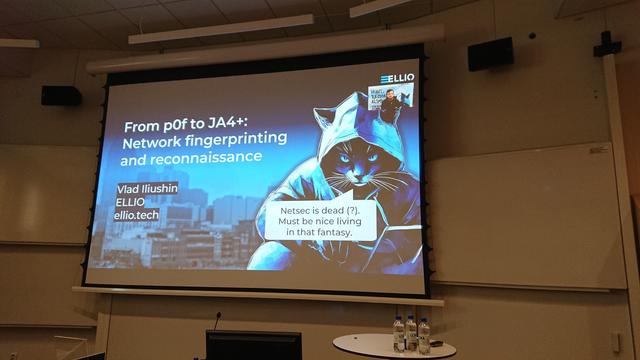 A lecture slide with the title of the talk and a picture of a hacker cat