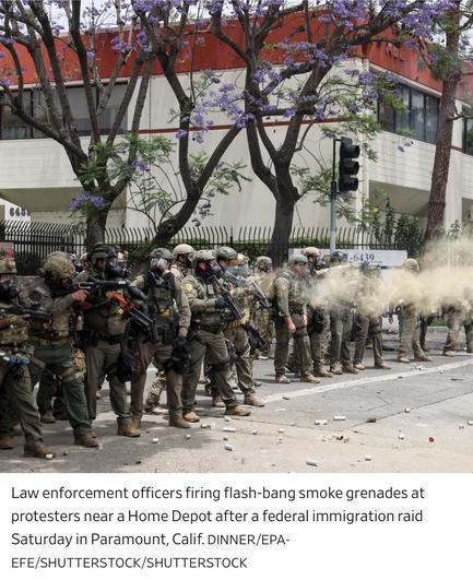 A group of law enforcement officers in tactical gear is seen firing flash-bang smoke grenades at protesters near a Home Depot. The scene appears tense, with debris scattered on the ground and blooming purple trees in the background.