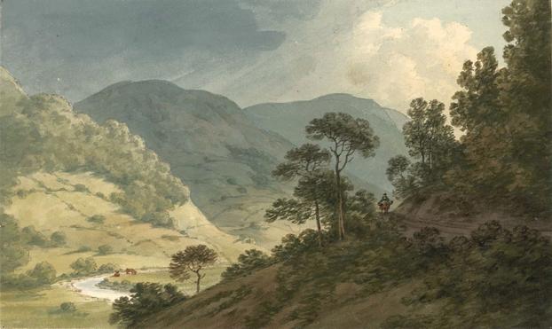 A rider and horse on wooded mountain road snaking its way through a slope in the foreground. In the background a sunny valley behind which semi-wooded mountains are rearing into the sky.