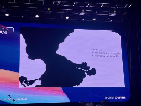 The image shows a presentation slide, out of Jess keynote, featuring a dark silhouette of a map, the Atlantic Ocean, south on top, north at bottom, Africa on the left, South America on the right. The text on the slide reads: "Two notes: on perspective and on language majority and minority worlds."