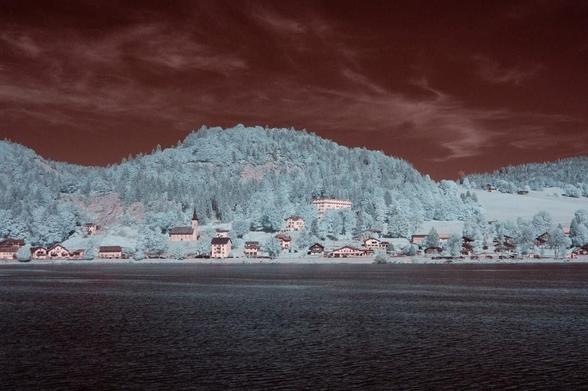 Paysage pris en infrarouge avec donc des couleurs zarbi. Ciel rouge, arbre bleu clair et lac sombre