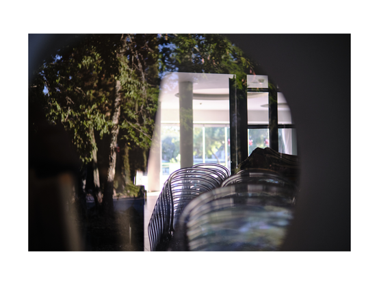 view through window of a venue building woth dtacks of chairs, tables and weird reflexions in the window pane