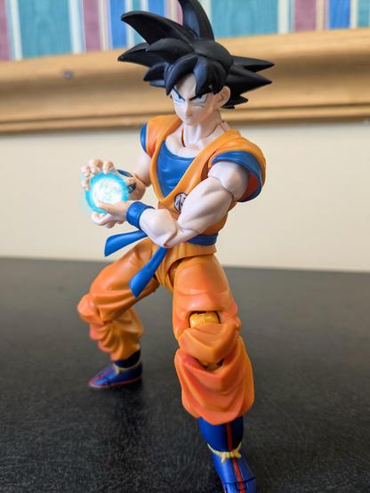 The S. H. Figuarts Goku in a kamehameha preparation pose with a poorly edited energy ball