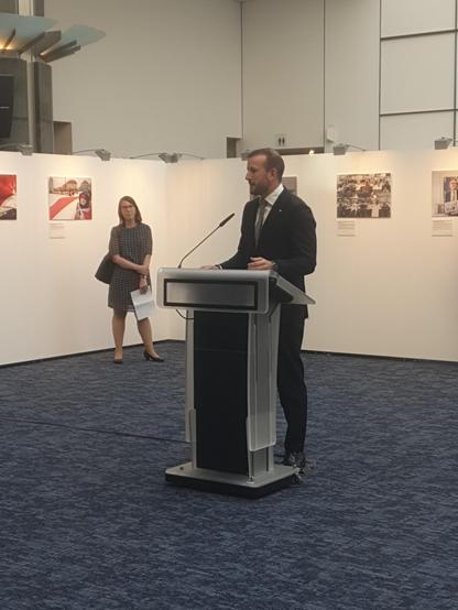 Photo of member of European Parliament speaker in front of photo exhibition in the European Parliament building in Brussels