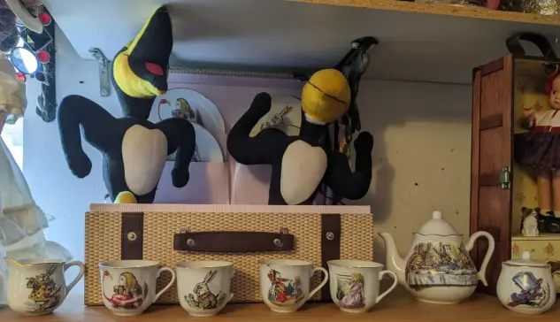 Heckle and Jeckle amid a set of Alice in Wonderland tea things.