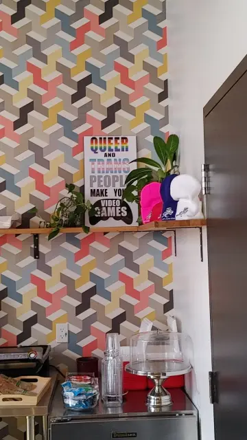A picture of Ubisoft's kitchen. There's a poster on the wall that says, "Queer and Trans People Make Your Video Games."