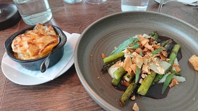 a vegetarian dinner, grilled asparagus with fried chips and sauce, and a side dish of potatoes au gratin
