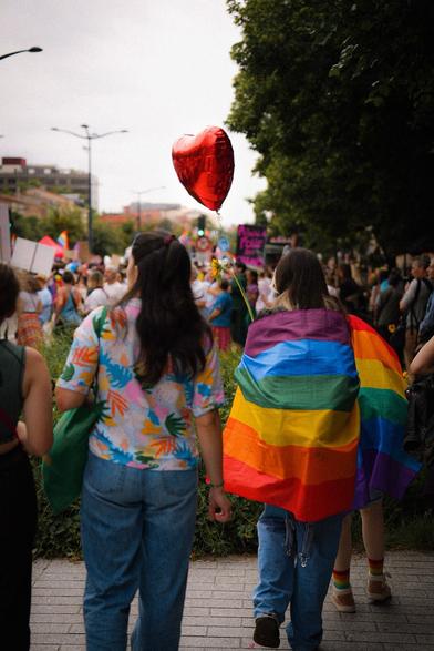 personnes de dos avec drapeau LGBTQIA+