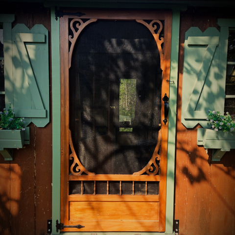 a screen door on a tiny cabin
