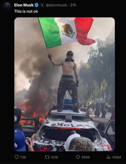 Elon Musk tweeting a photo of a masked man with nude chest standing atop a burning Waymo car, surrounded by smoke and chaos and waving a big flag of Mexico. Musk comments: „This is not ok.“