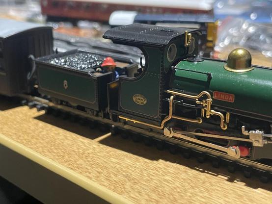 A model narrow gauge steam locomotive with Paddington Bear stood on the footplate