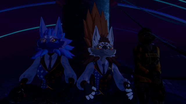 VRChat photo of a trio of avatar watching a fireworks display from a domed rooftop.

On the left, a purple Novabeast with varying shades of purple hair, deep blue star-themed waistcoat and trousers and a white puffy shirt.
In the middle, a white Novabeat with brown hair, deep blue star-themed waistcoat and trousers and a white puffy shirt.
On the right, a brown bunny with brown hair, yellow and black hoodie and yellow shorts.