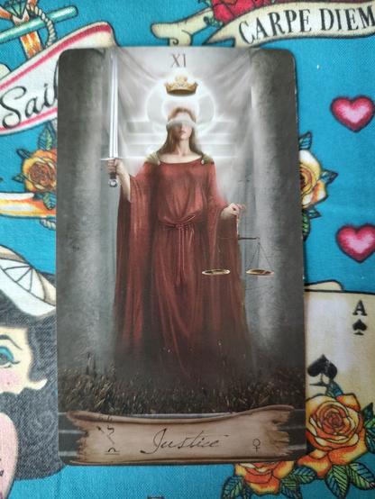 Card from the Heaven and Earth Tarot deck. 
Justice-XI.
A lady in red robes, blindfolded, holds scales on the left hand, a sword pointed upward on the right hand.
