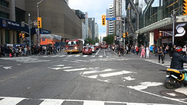 Bloor at Yonge looking eastward with fire trucks and people waiting for shuttle buses due to the subway closure.