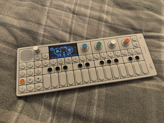 A Teenage Engineering OP-1 synthesiser with a virtual tape displayed on screen.