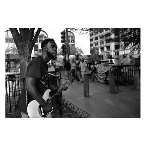 Street musician playing his electric guitar on the sidewalk of the Department of the Treasury in Washington DC