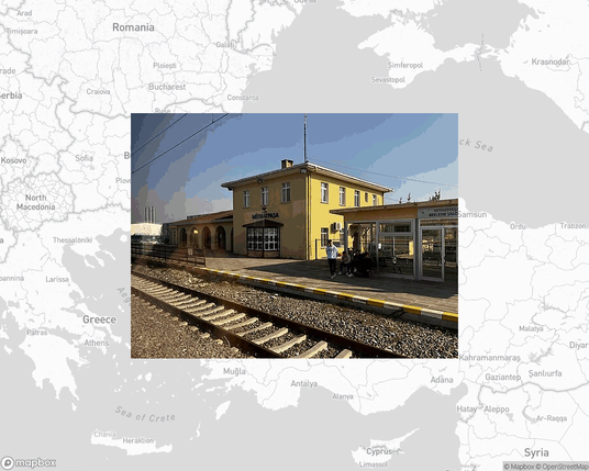 A photo of or from a train station from the linked website, overlaid on a cropped world map where it's located.