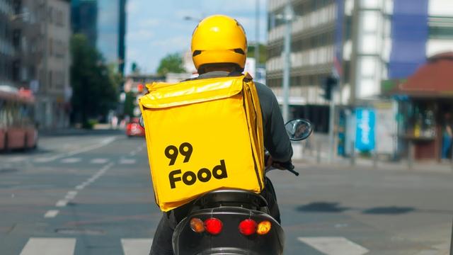 <figure class="wp-block-image size-large wp-lightbox-container"><img alt="Motociclista com caixa de entrega da 99Food" class="wp-image-832631" height="596" src="https://files.tecnoblog.net/wp-content/uploads/2025/06/99food-moto-1060x596.jpg" width="1060" /><button class="lightbox-trigger" type="button">
			<svg fill="none" height="12" viewBox="0 0 12 12" width="12" xmlns="http://www.w3.org/2000/svg">
				<path d="M2 0a2 2 0 0 0-2 2v2h1.5V2a.5.5 0 0 1 .5-.5h2V0H2Zm2 10.5H2a.5.5 0 0 1-.5-.5V8H0v2a2 2 0 0 0 2 2h2v-1.5ZM8 12v-1.5h2a.5.5 0 0 0 .5-.5V8H12v2a2 2 0 0 1-2 2H8Zm2-12a2 2 0 0 1 2 2v2h-1.5V2a.5.5 0 0 0-.5-.5H8V0h2Z" fill="#fff">
			</svg>
		</button><figcaption class="wp-element-caption">99Food está de volta ao Brasil (imagem: divulgação/99)</figcaption></figure>


<details class="tb-resumo tb-callout padrao">
    Resumo
    <div class="tb-resumo-topicos tb-callout-texto"><ul>
<li>A 99Food iniciou uma fase piloto em Goiânia para retomar entregas e competir com o iFood.</li>
<li>A chinesa Didi, controladora da 99, deve investir R$ 1 bilhão na expansão da 99Food no Brasil.</li>
<li>Para competir, a 99 oferece uma remuneração mínima de R$ 250 aos entregadores que realizarem pelo menos 20 corridas por dia. Restaurantes terão isenção total de taxas por 24 meses.</li>
</ul>
</div>
</details>


<p>A 99Food está de volta. Em fase piloto, mas está. Nesta semana, o serviço começou a operar em Goiânia (GO) e, com isso, dá os primeiros passos para retomar o seu serviço de entregas de