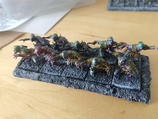 A unit of ten ghouls/zombies on a movement tray, depicted mid charge. They are all painted a bit differently from when I experimented with (rotten) skin tones.
