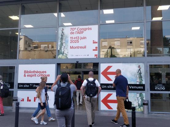 Plusieurs personnes se dirigeant vers l’entrée du centre des congrès de Montreuil. Au-dessus de la porte, on peut lire « 70e congrès de l’ABF ».