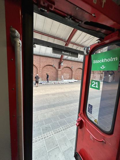 A photo out of the open side door of the EN 346 to Stockholm. It shows a platform of Malmö Central.