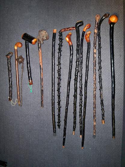 A collection of shillelagh with different ends, some circular knobs, some hammer-like; some of the sticks are smoothed, some have thorny protrusions.