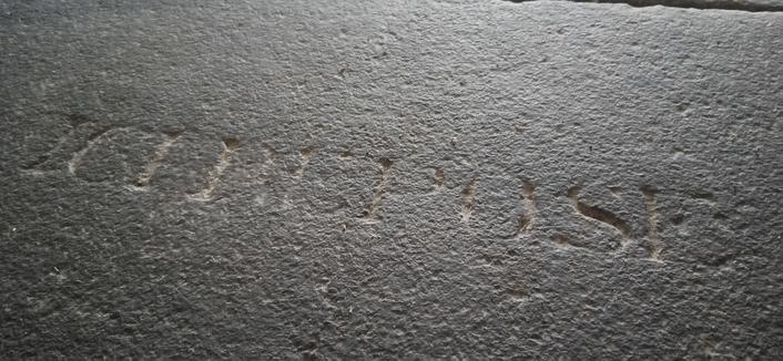 Une pierre tombale dans l'église, avec l'inscription bien visible ICI REPOSE