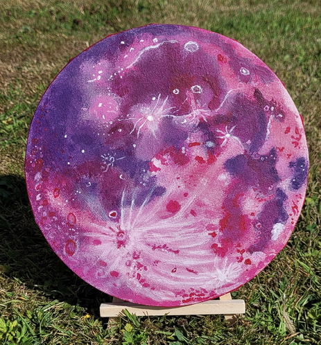 An 8" canvas with a pink Strawberry Moon painted on it.