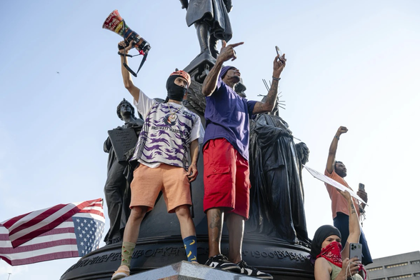 Protesters cheer from pedestal of a statue during a protest against Immigration and Customs Enforcement and the Trump administration at Metro Hall, Monday, June 9, 2025, in Louisville, Ky (AP/Jon Cherry)