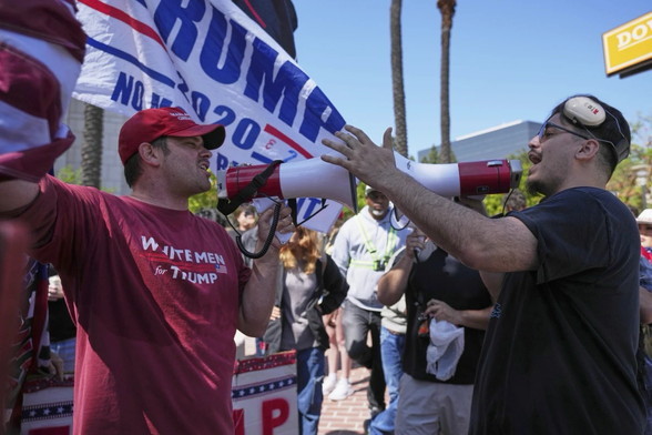 A protester wearing a shirt reading “WHITE MEN for TRUMP” argues with another protester Tuesday, June 10, 2025, in Santa Ana, Calif. (AP Photo/Jae C. Hong)