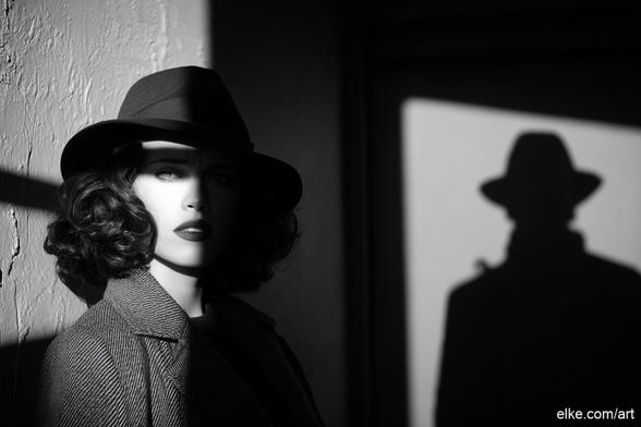 A mysterious woman in classic 1940s attire stands in dramatic shadow, her expression caught between elegance and tension.

The sharp contrast of black and white light evokes vintage Hollywood crime thrillers, while the silhouette of a man in a fedora behind her hints at intrigue and suspense.

This cinematic composition captures the essence of the film noir era with style and storytelling.

Perfect for home theaters, study rooms, or retro-inspired interiors.

Ideal for collectors of film noir art, classic cinema lovers, or fans of moody black-and-white photography.