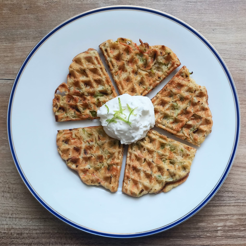 eine runde in 5 Stücke geteilte Waffel mit einem Klecks Dip in der Mitte.