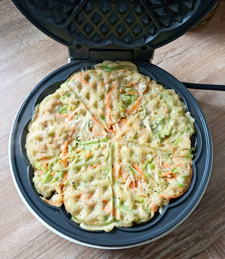 ein rundes Waffeleisen mit dem Gemüse-Teig.