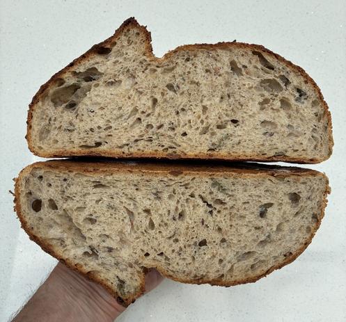 Crumb shot showing textured sourdough with seeds and sage.